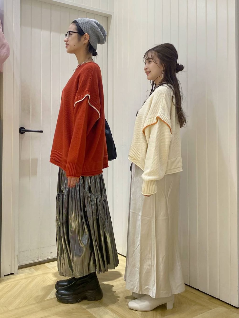 レッド系のニット/セーター、ホワイト系のニット/セーター、ブラウン系のショルダーバッグを着用したレディースの秋コーディネートの2枚目の写真