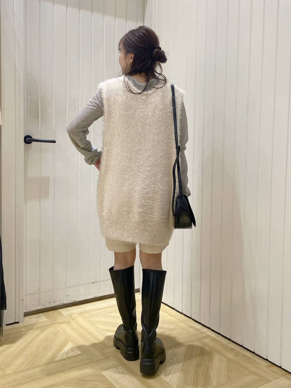 ブラック系のショルダーバッグ、ホワイト系のTシャツ/カットソー、ホワイト系のベストを着用したレディースの秋コーディネートの3枚目の写真