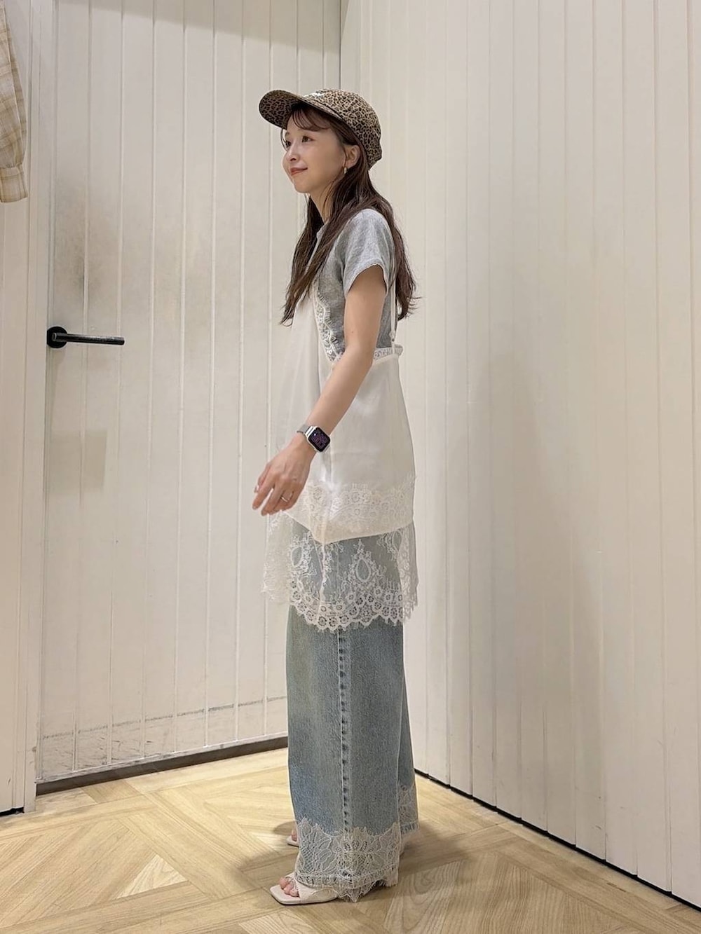 ブルー系のデニムパンツ、ホワイト系のサンダル、ホワイト系のTシャツ/カットソーを着用したレディースの夏コーディネートの2枚目の写真