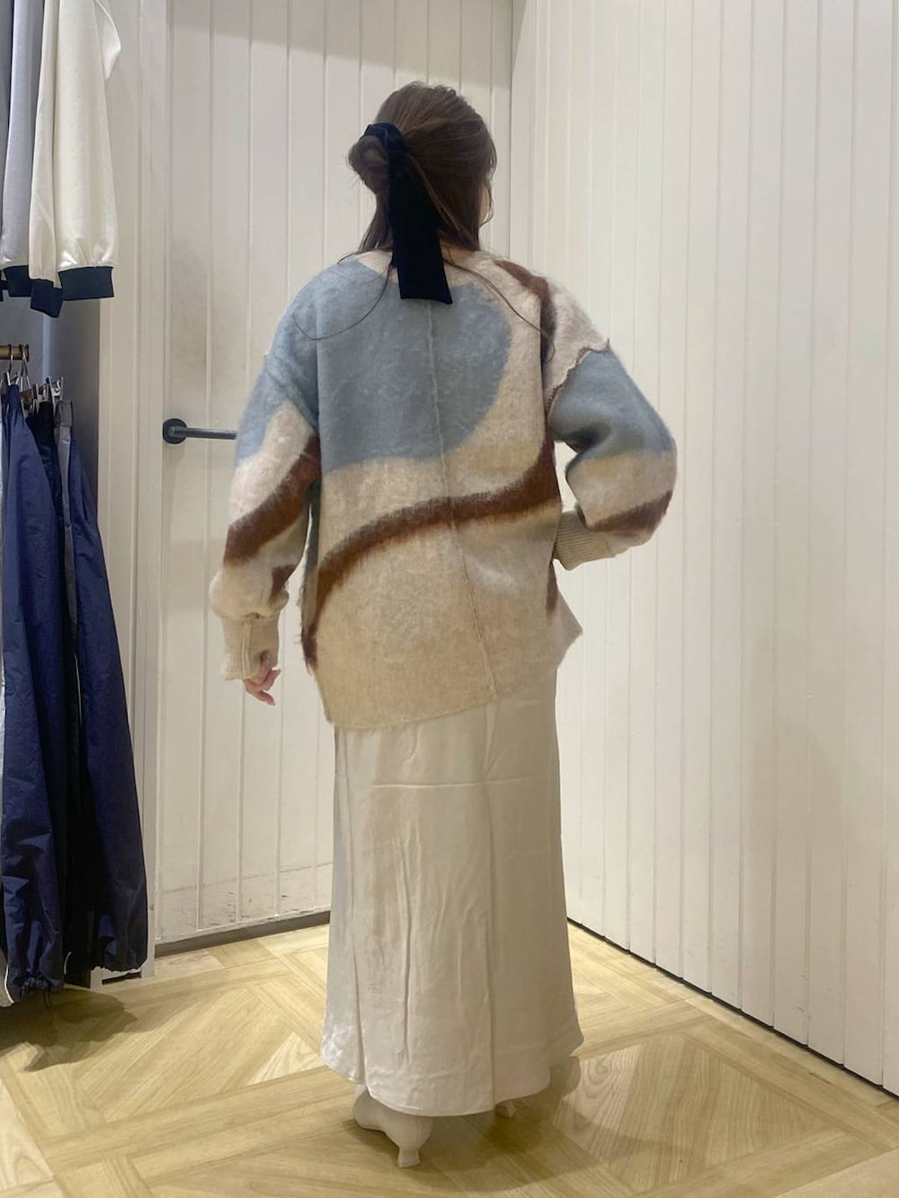 ホワイト系のスカート、ホワイト系のブーツ、ホワイト系のニット/セーターを着用したレディースの秋コーディネートの3枚目の写真