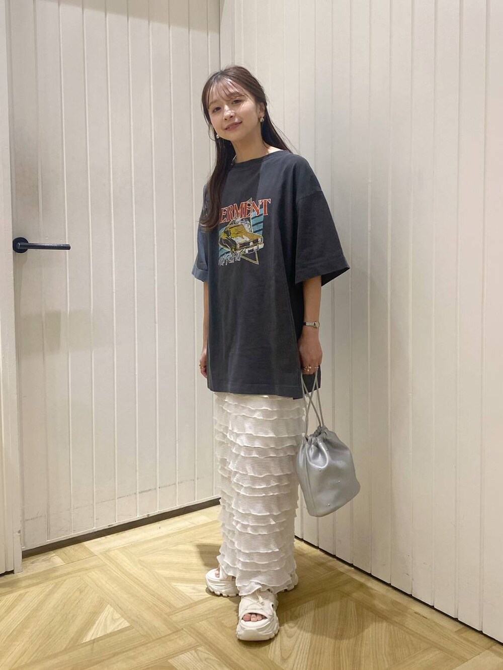 ホワイト系のサンダル、ホワイト系のスカート、シルバー系のショルダーバッグを着用したレディースの春コーディネートの2枚目の写真