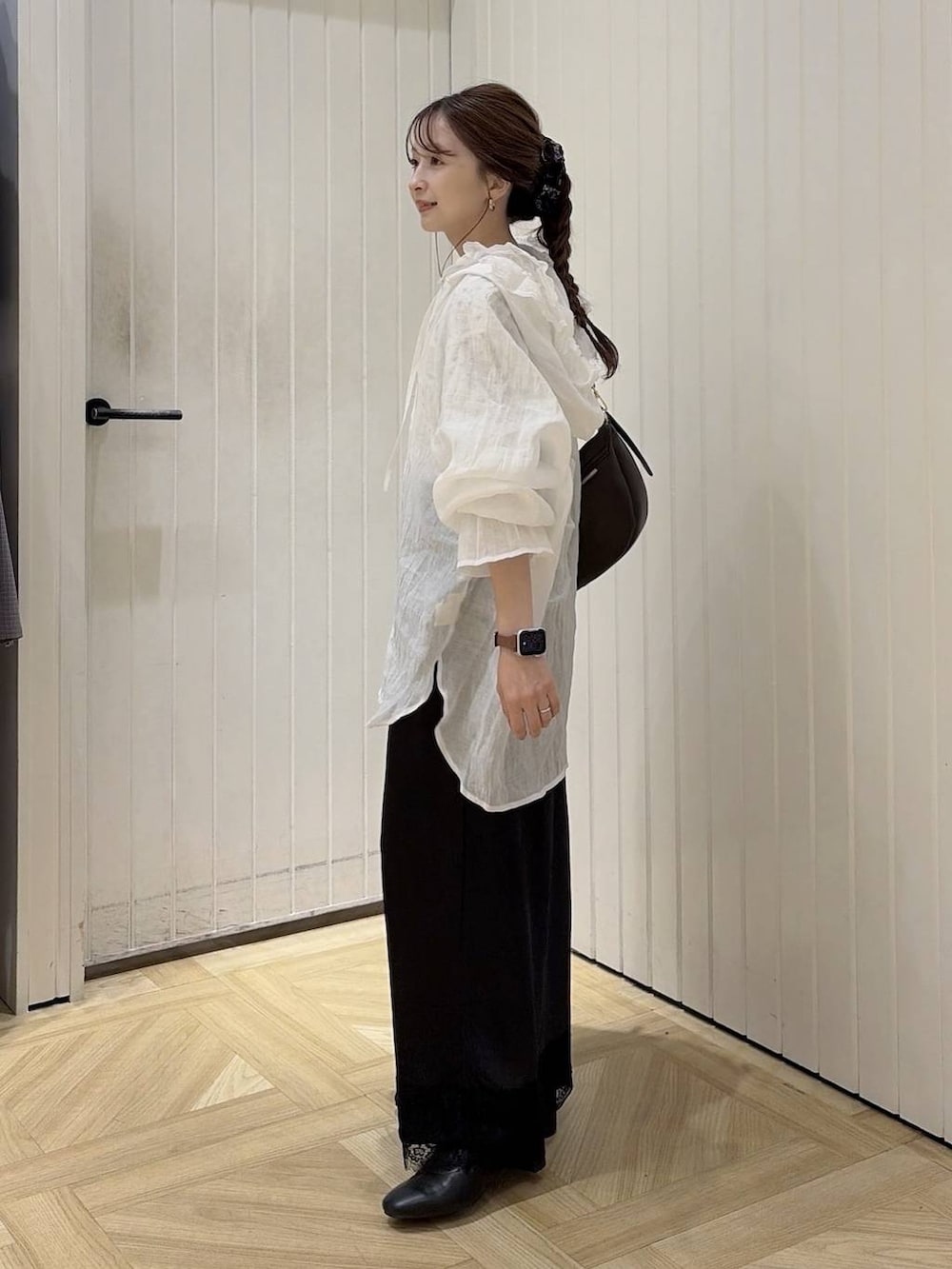 ブラウン系のショルダーバッグ、ブラック系のブーツ、ホワイト系のTシャツ/カットソーを着用したレディースの秋コーディネートの2枚目の写真