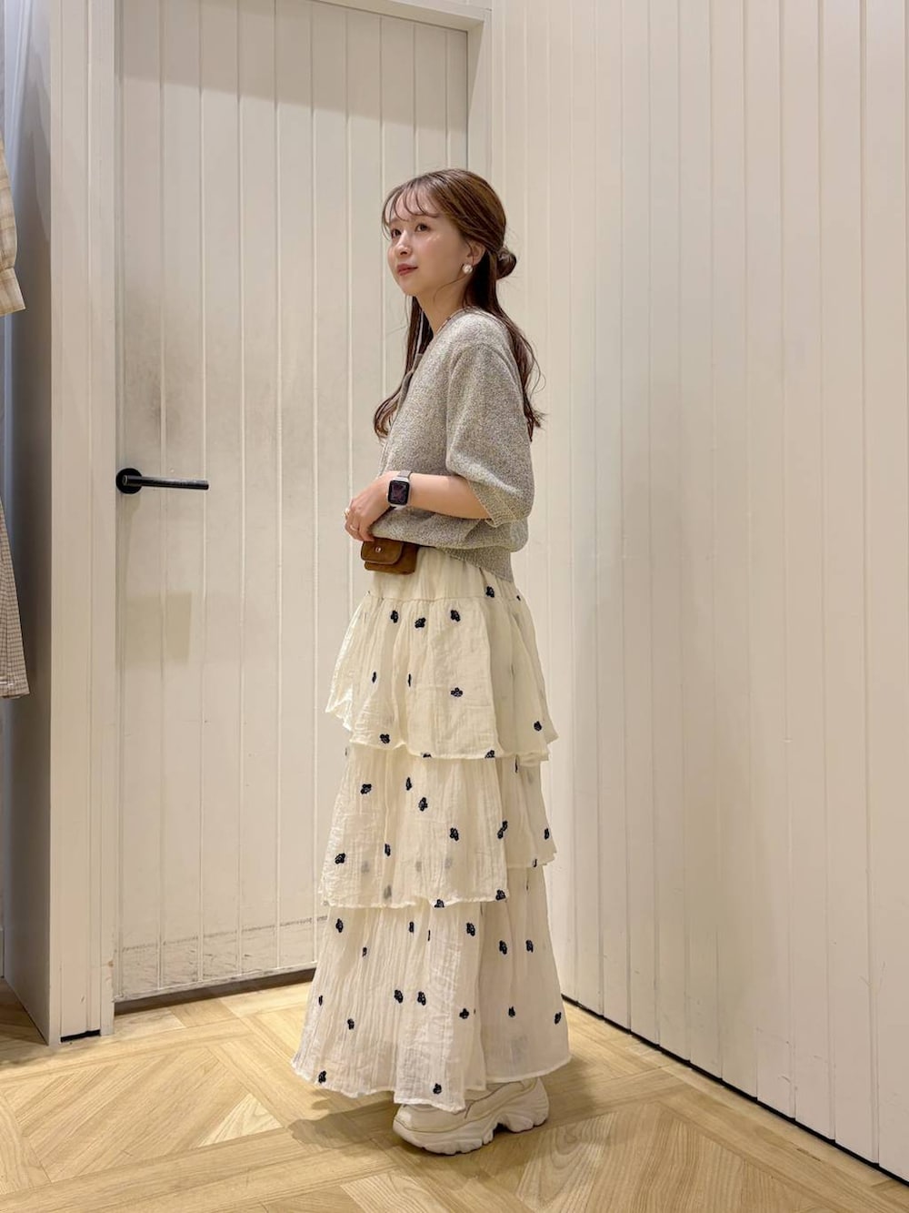 ホワイト系のスカート、グレー系のTシャツ/カットソー、ホワイト系のスニーカーを着用したレディースの春コーディネートの2枚目の写真