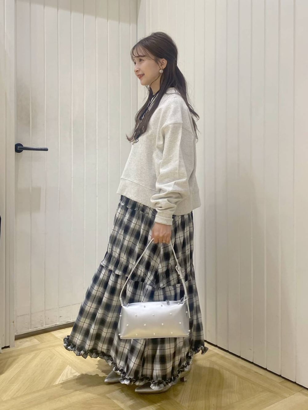 ブラック系のスカート、シルバー系のブーツ、グレー系のスウェットを着用したレディースの秋コーディネートの2枚目の写真