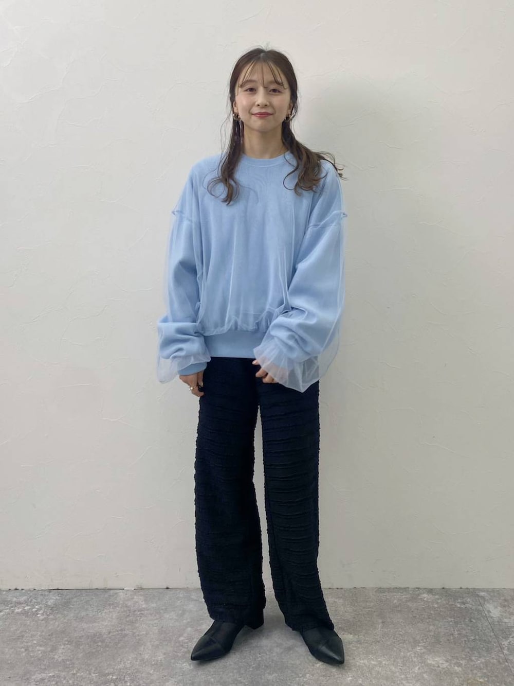 ブラック系のその他パンツ、ブラック系のブーツ、ブルー系のTシャツ/カットソーを着用したレディースの冬コーディネートの3枚目の写真