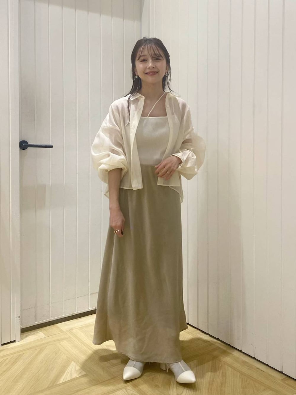 グリーン系のスカート、ホワイト系のブーツ、ホワイト系のシャツ/ブラウスを着用したレディースの春コーディネートの2枚目の写真