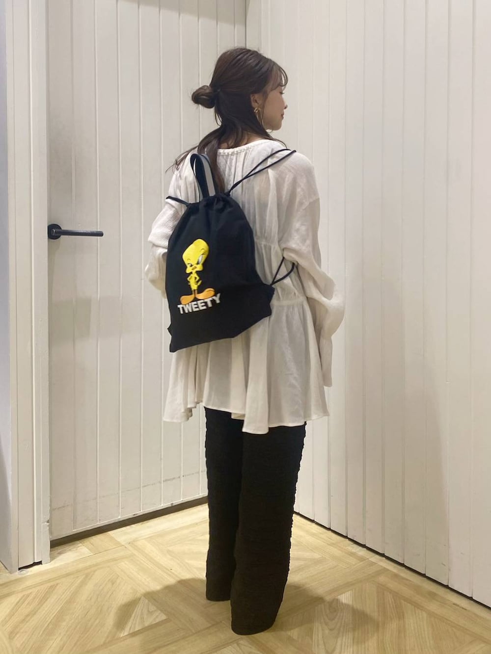 ホワイト系のブーツ、ブラック系のバックパック/リュック、ホワイト系のシャツ/ブラウスを着用したレディースの春コーディネートの4枚目の写真