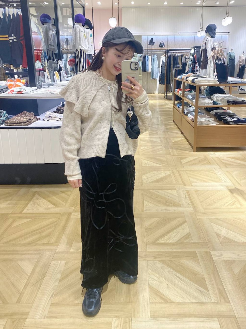 ブラック系のその他シューズ、ホワイト系のカーディガン/ボレロ、ブラック系のスカートを着用したレディースの秋コーディネートの2枚目の写真