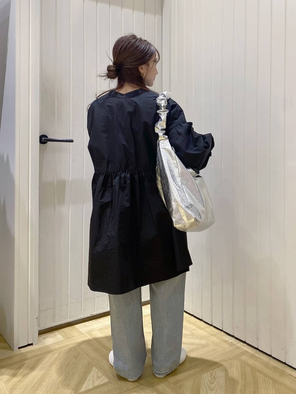 グレー系のトートバッグ、ブラック系のワンピース、ブルー系のデニムパンツを着用したレディースの春コーディネートの3枚目の写真