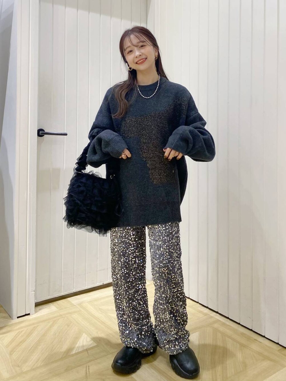 ブラック系のショルダーバッグ、ブラック系のブーツ、シルバー系のその他パンツを着用したレディースの冬コーディネートの2枚目の写真