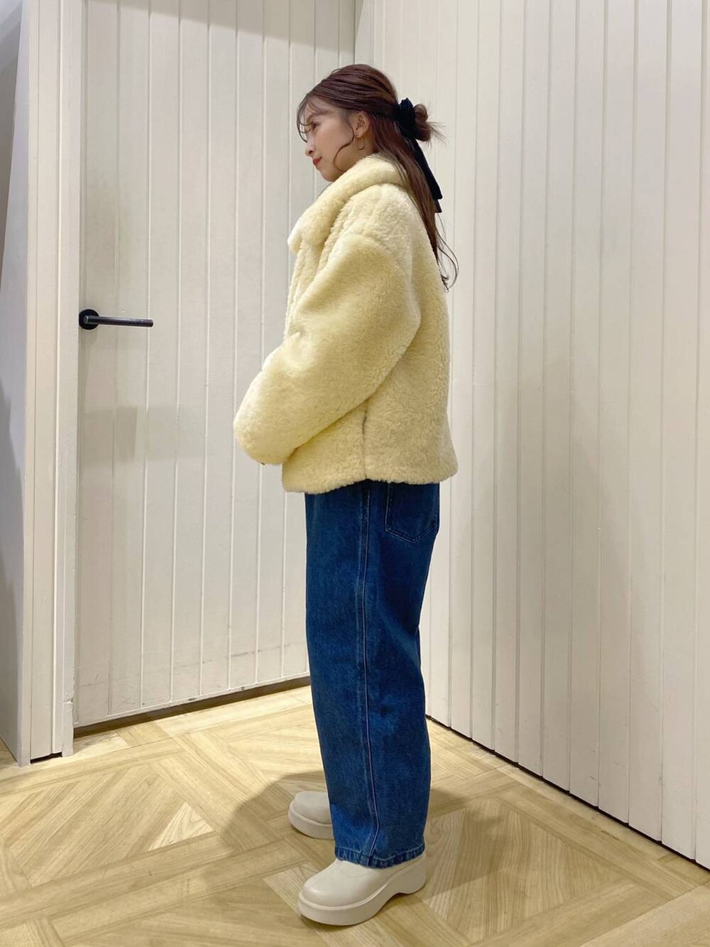 ホワイト系のTシャツ/カットソー、ホワイト系のブーツ、イエロー系のブルゾンを着用したレディースの冬コーディネートの2枚目の写真