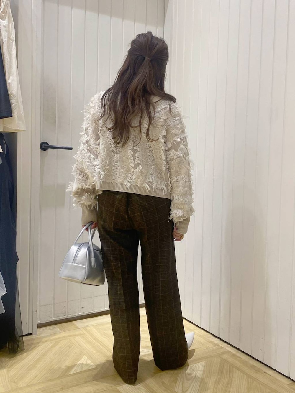 ブラウン系のスラックス、シルバー系のボストンバッグ、ホワイト系のブーツを着用したレディースの秋コーディネートの4枚目の写真