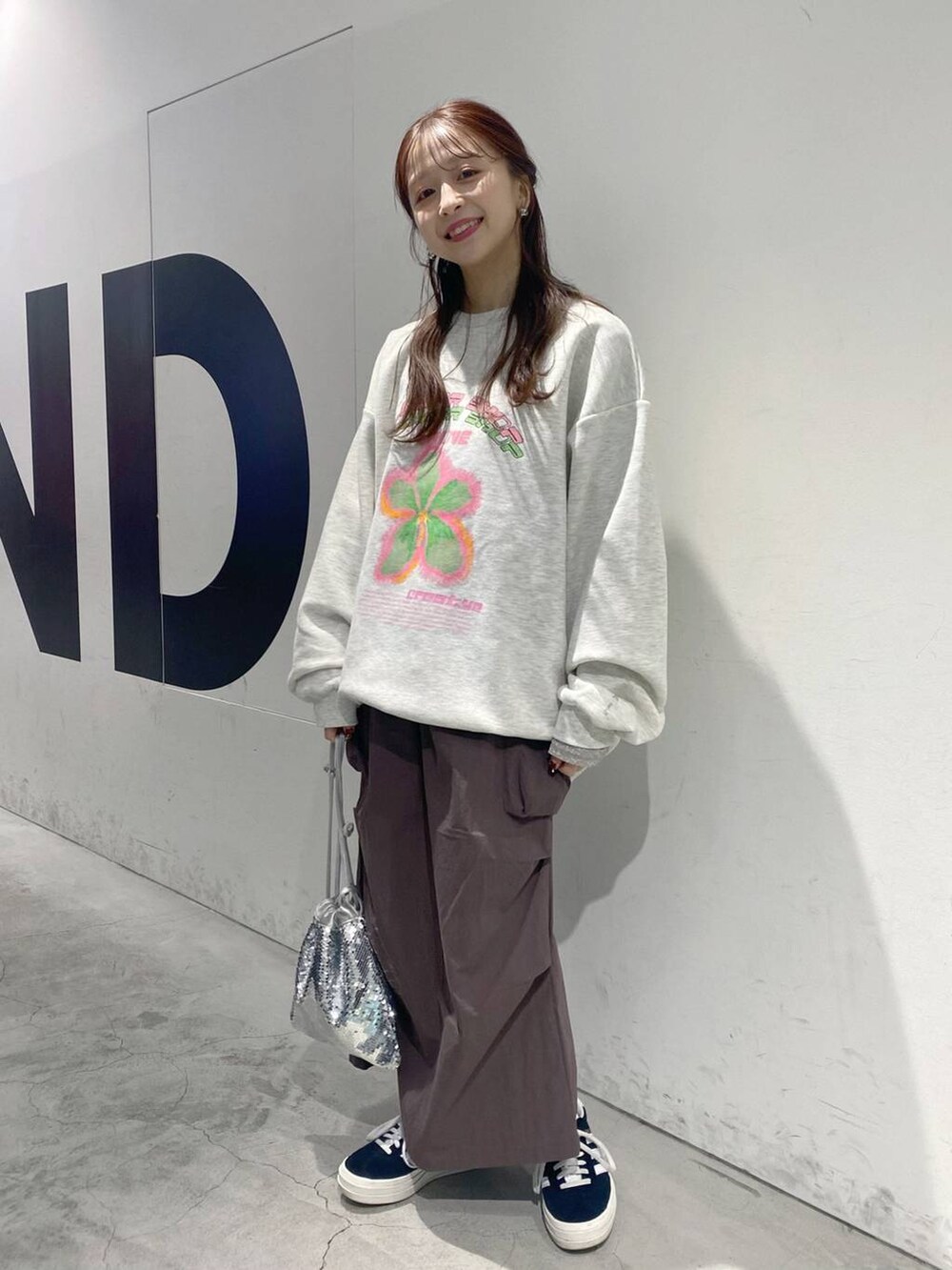 グレー系のスウェット、ブラウン系のスカートを着用したレディースの冬コーディネートの2枚目の写真