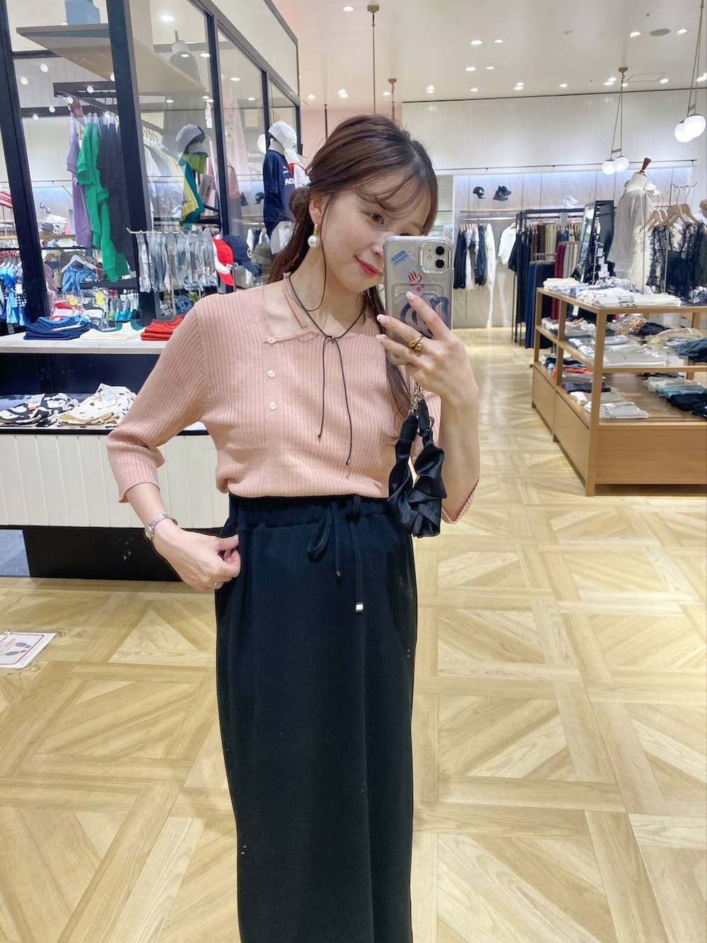 ブラック系のスカート、ブラック系のサンダル、ピンク系のニット/セーターを着用したレディースの夏コーディネートの2枚目の写真