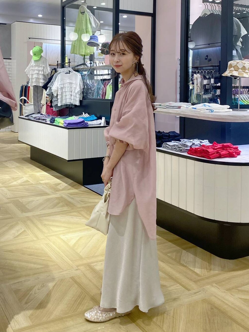 ベージュ系のハンドバッグ、ホワイト系のTシャツ/カットソー、ピンク系のシャツ/ブラウスを着用したレディースの夏コーディネートの2枚目の写真