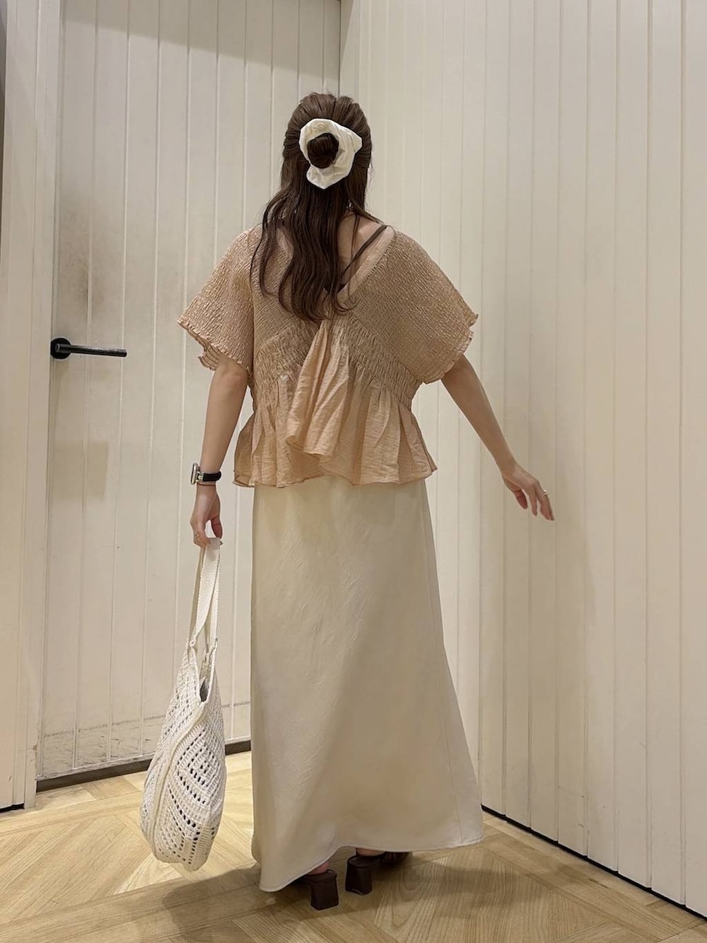 ブラウン系のTシャツ/カットソー、ホワイト系のスカート、ブラウン系のサンダルを着用したレディースの夏コーディネートの3枚目の写真