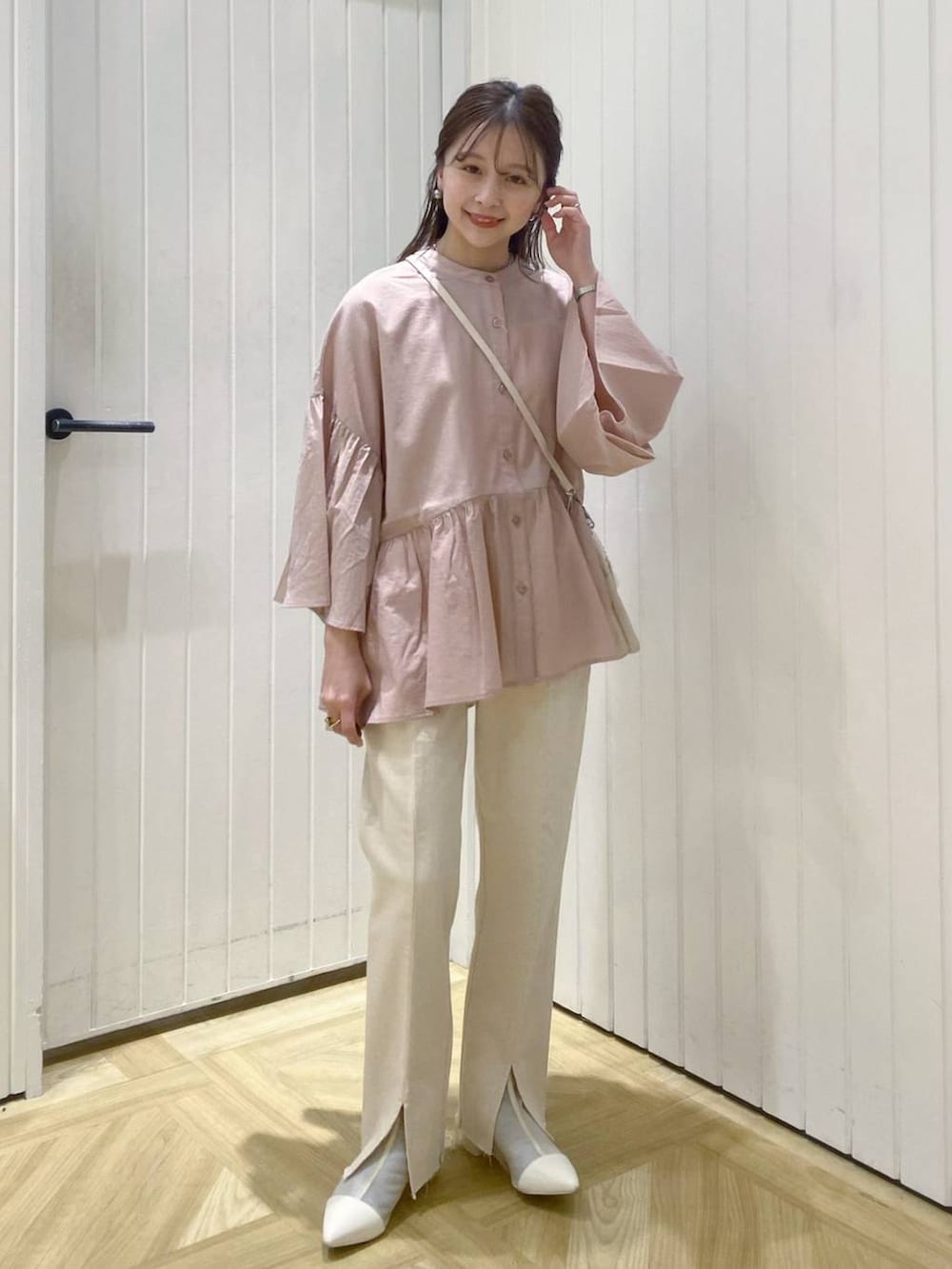 ベージュ系のショルダーバッグ、ホワイト系のブーツ、ピンク系のシャツ/ブラウスを着用したレディースの春コーディネートの2枚目の写真