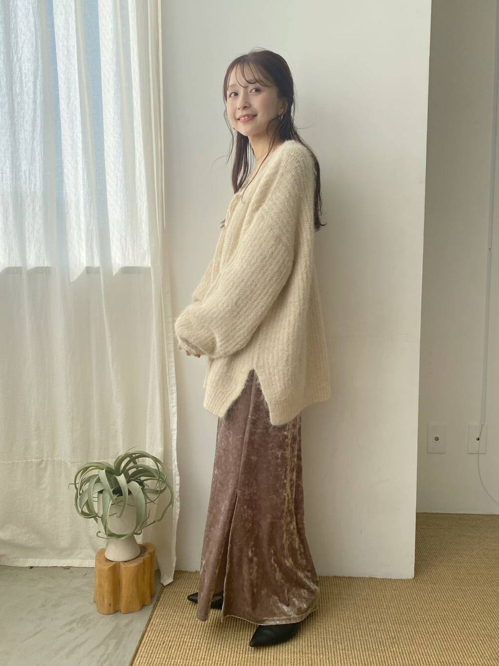 ホワイト系のキャミソール、ホワイト系のニット/セーター、ピンク系のスカートを着用したレディースの秋コーディネートの2枚目の写真