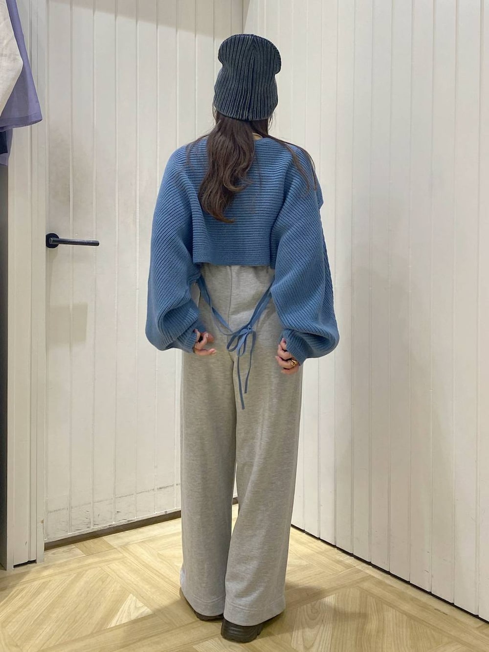 ブラック系のブーツ、ブルー系のニット/セーター、グレー系のスウェットパンツを着用したレディースの秋コーディネートの2枚目の写真