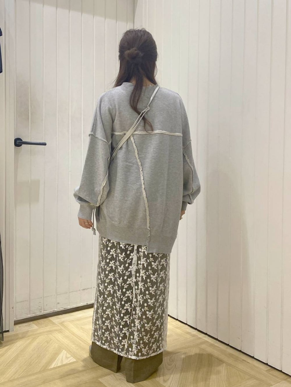 ブラウン系のスラックス、ホワイト系のスカート、シルバー系のショルダーバッグを着用したレディースの秋コーディネートの4枚目の写真