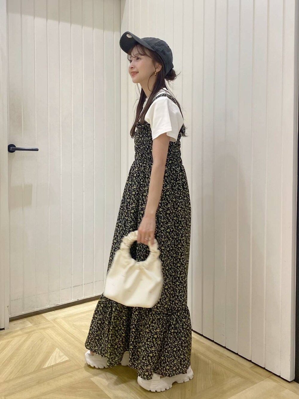 ベージュ系のハンドバッグ、ホワイト系のサンダル、その他のワンピースを着用したレディースの春コーディネートの3枚目の写真