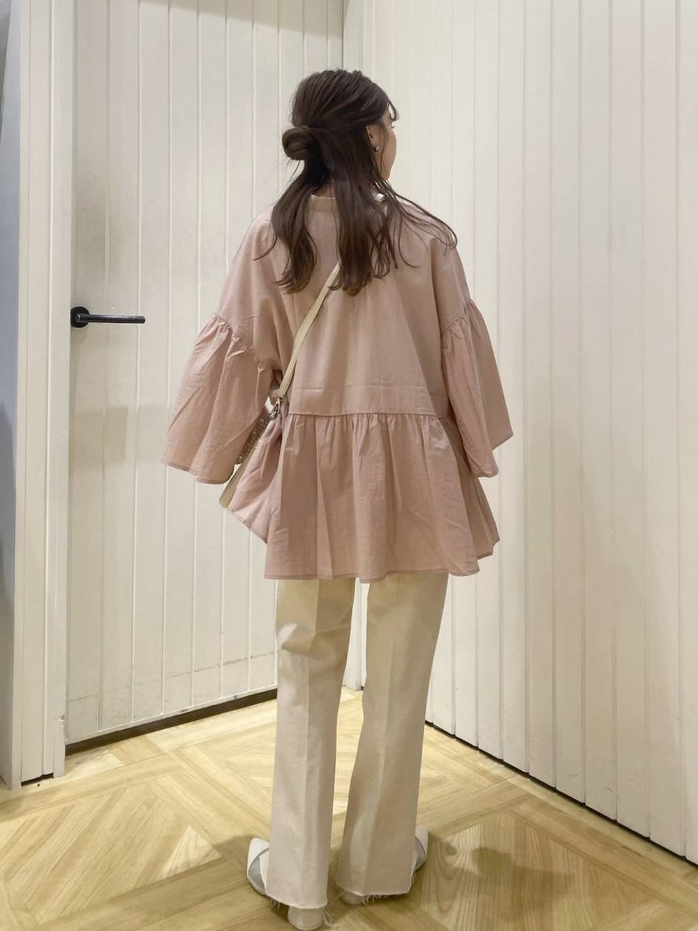 ベージュ系のショルダーバッグ、ホワイト系のブーツ、ピンク系のシャツ/ブラウスを着用したレディースの春コーディネートの4枚目の写真