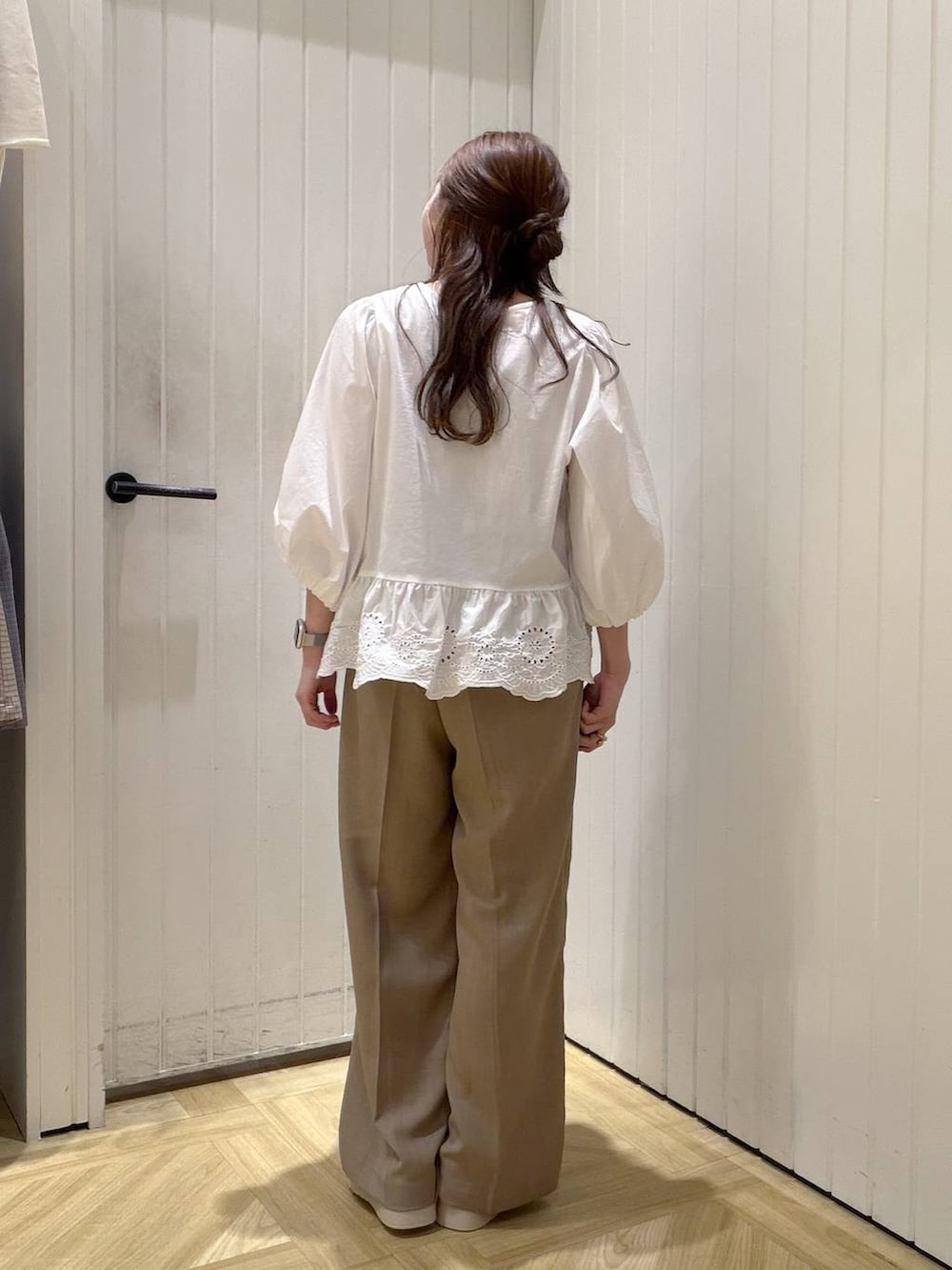 ベージュ系のスラックス、ホワイト系のサンダル、ホワイト系のシャツ/ブラウスを着用したレディースの春コーディネートの3枚目の写真