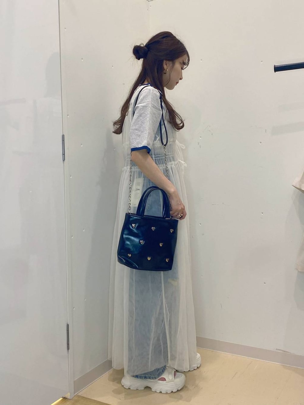 ホワイト系のサンダル、グレー系のTシャツ/カットソー、ブルー系のデニムパンツを着用したレディースの夏コーディネートの2枚目の写真