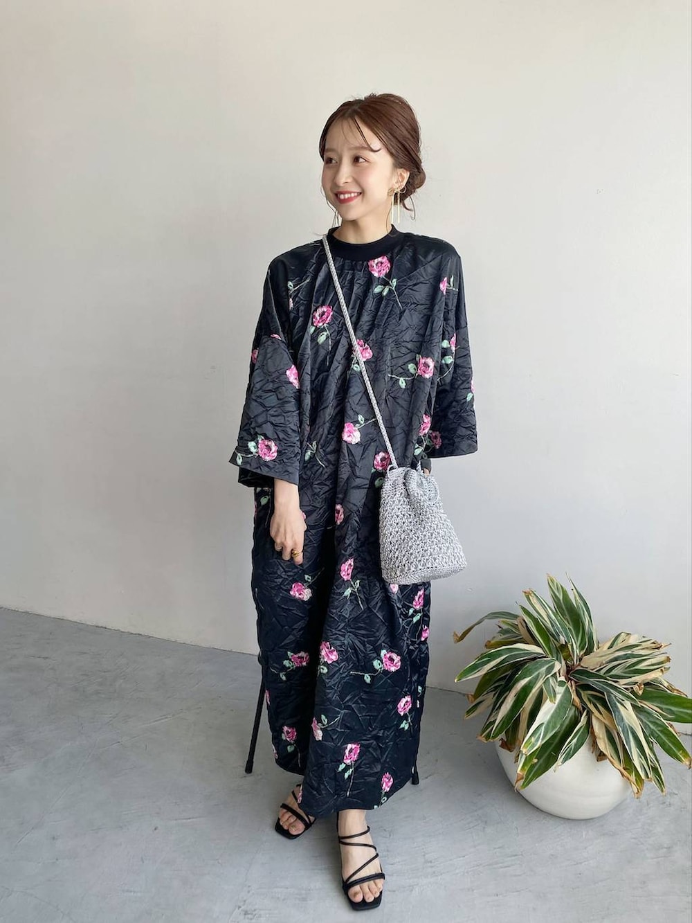 ブラック系のワンピース、ブラック系のサンダル、グレー系のショルダーバッグを着用したレディースの春コーディネートの2枚目の写真