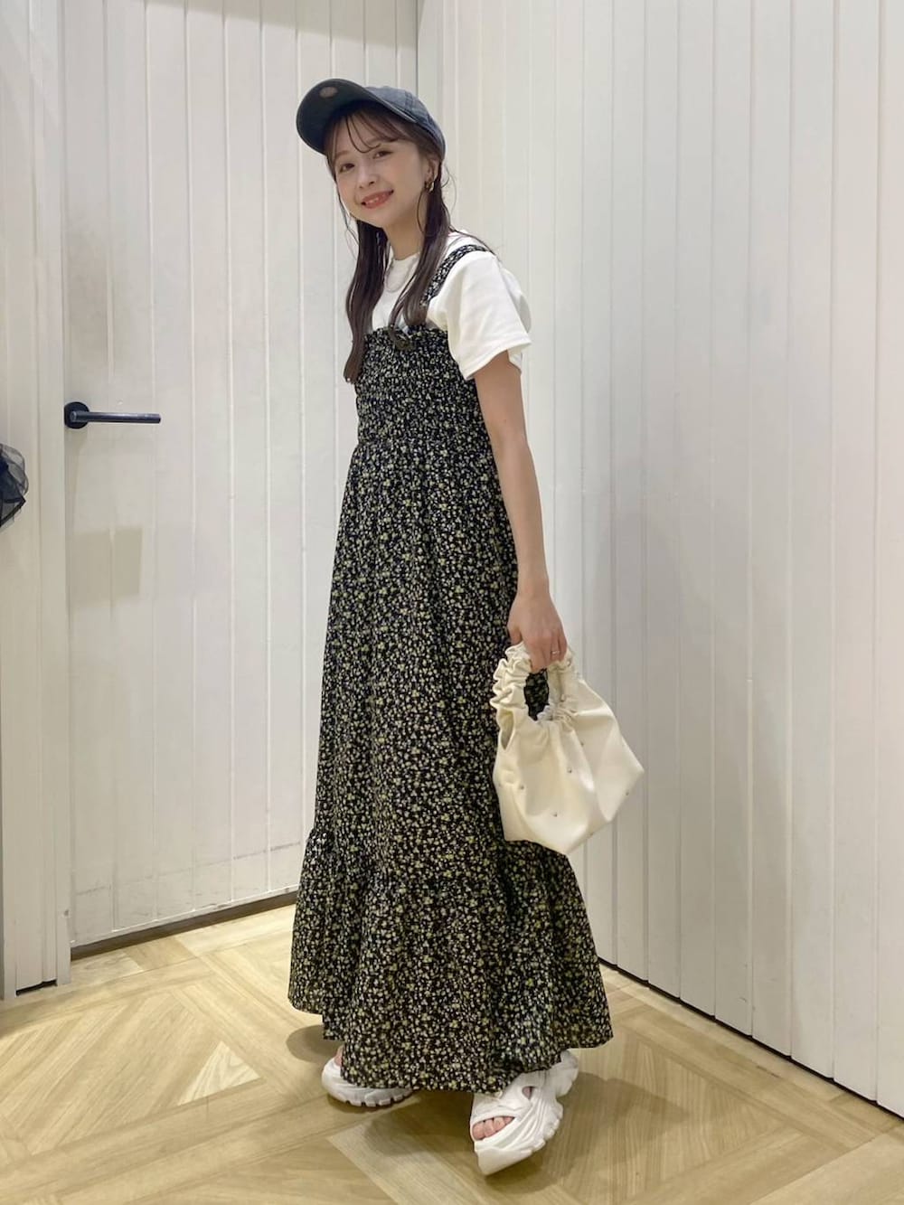 ベージュ系のハンドバッグ、ホワイト系のサンダル、その他のワンピースを着用したレディースの春コーディネートの2枚目の写真