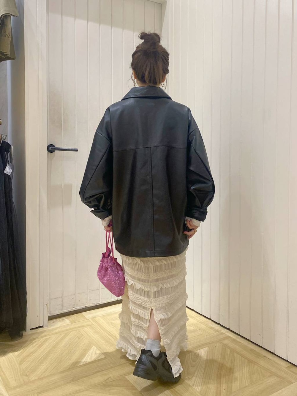 ブラック系のその他シューズ、ホワイト系のスカート、ピンク系のショルダーバッグを着用したレディースの秋コーディネートの3枚目の写真