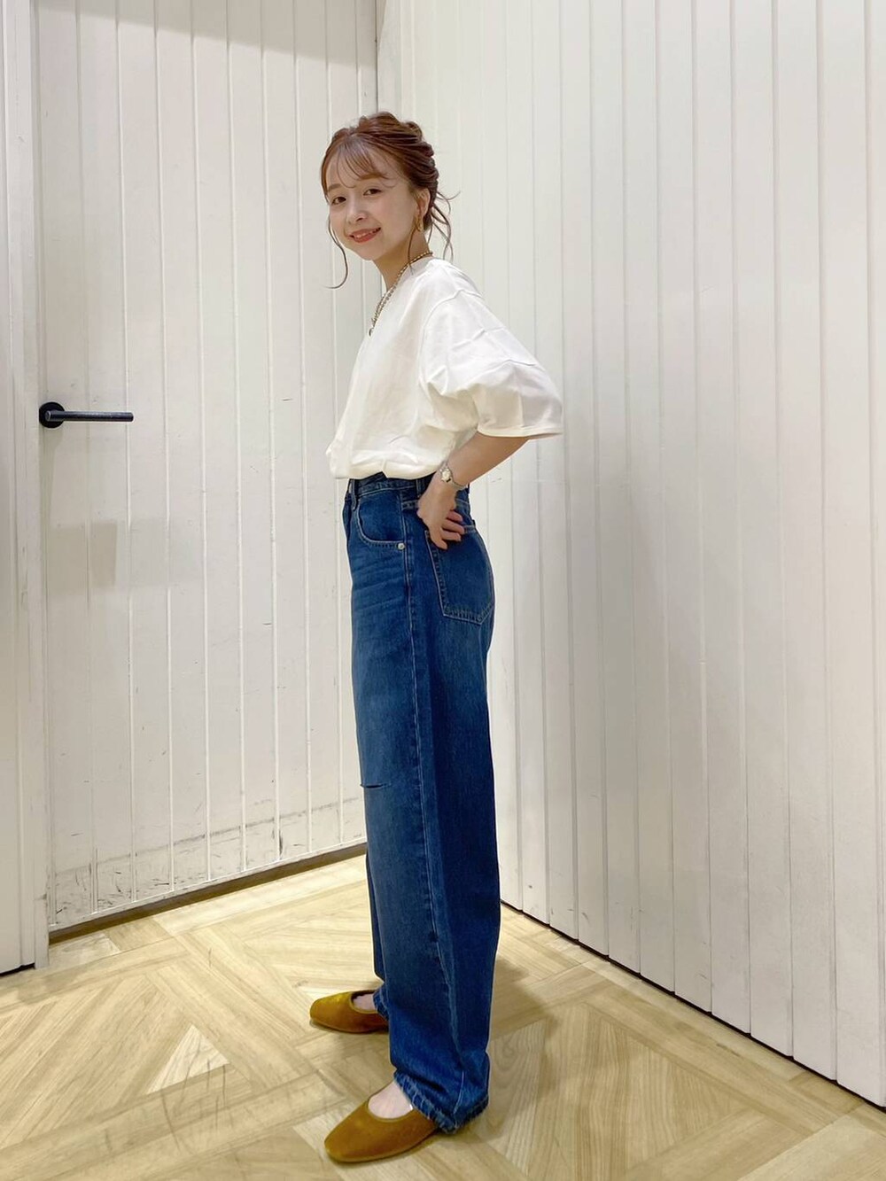 ブルー系のデニムパンツ、イエロー系のパンプス、ホワイト系のTシャツ/カットソーを着用したレディースの夏コーディネートの3枚目の写真