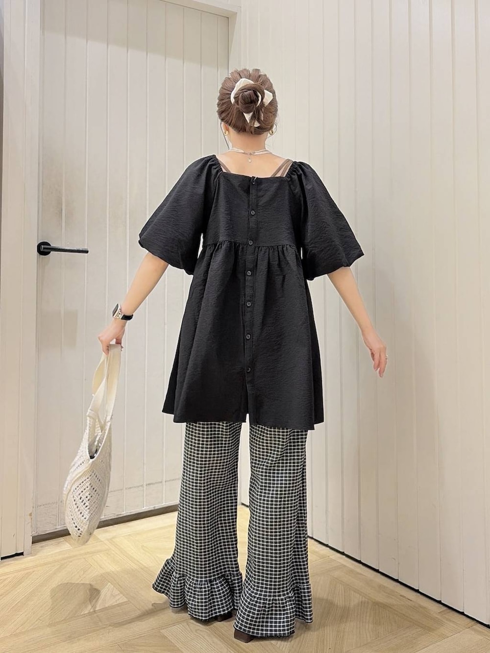ブラック系のシャツ/ブラウス、ブラウン系のサンダル、ホワイト系のトートバッグを着用したレディースの夏コーディネートの2枚目の写真