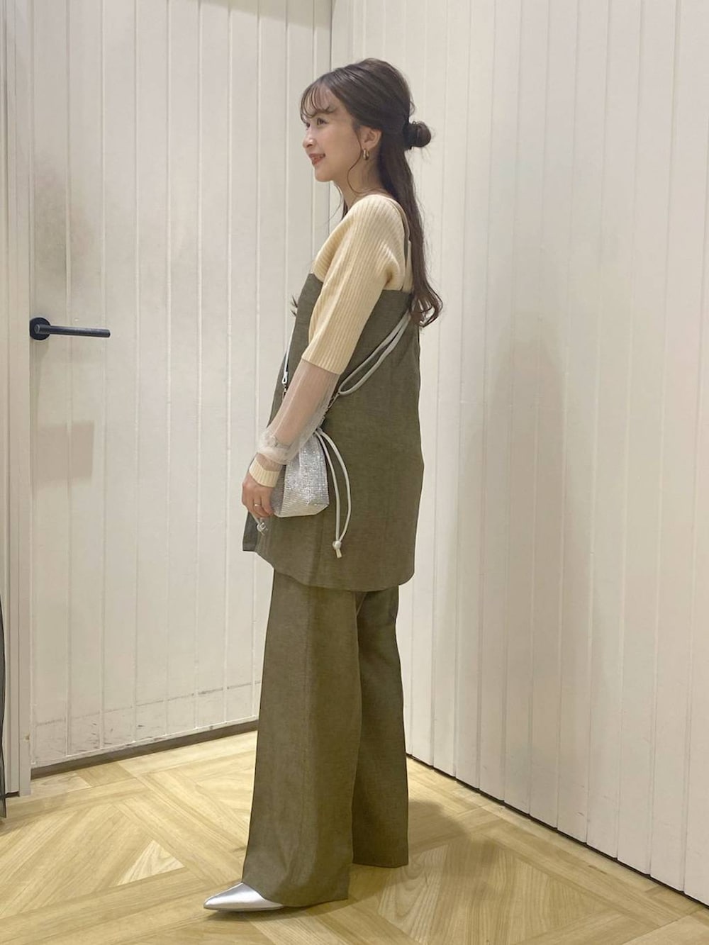 ブラウン系のスラックス、シルバー系のショルダーバッグ、シルバー系のブーツを着用したレディースの秋コーディネートの3枚目の写真