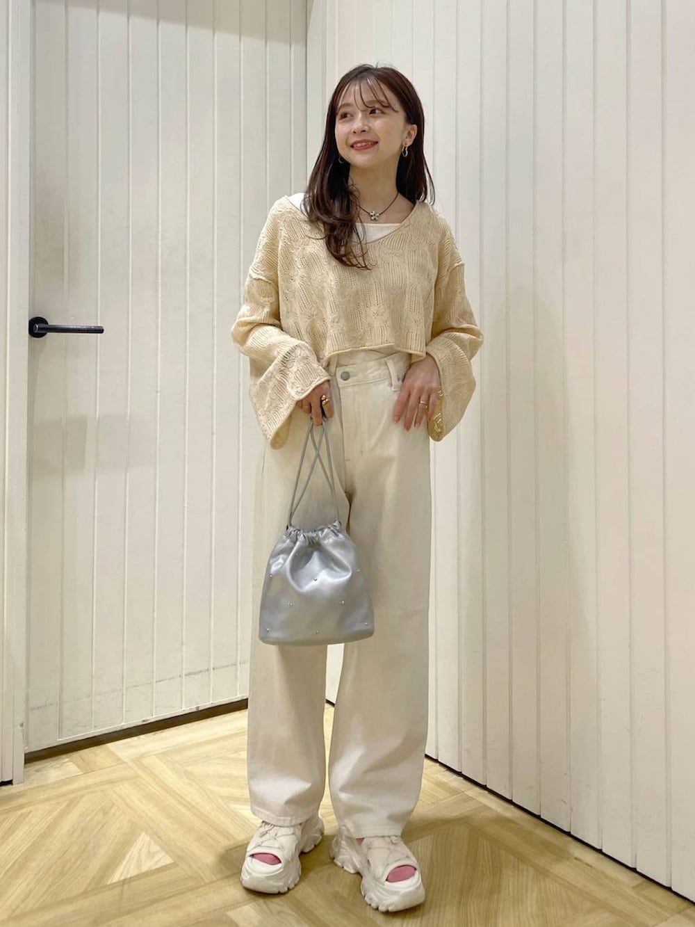 ホワイト系のサンダル、シルバー系のショルダーバッグ、ベージュ系のニット/セーターを着用したレディースの春コーディネートの3枚目の写真
