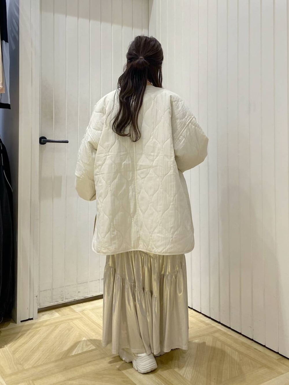 ホワイト系のブルゾン、ブルー系のニット/セーター、ホワイト系のスニーカーを着用したレディースの秋コーディネートの3枚目の写真