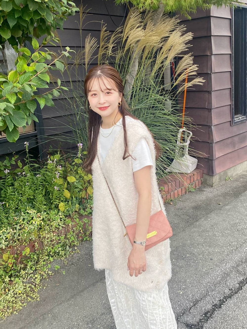 ホワイト系のTシャツ/カットソー、ホワイト系のベスト、ホワイト系のスカートを着用したレディースの秋コーディネートの2枚目の写真