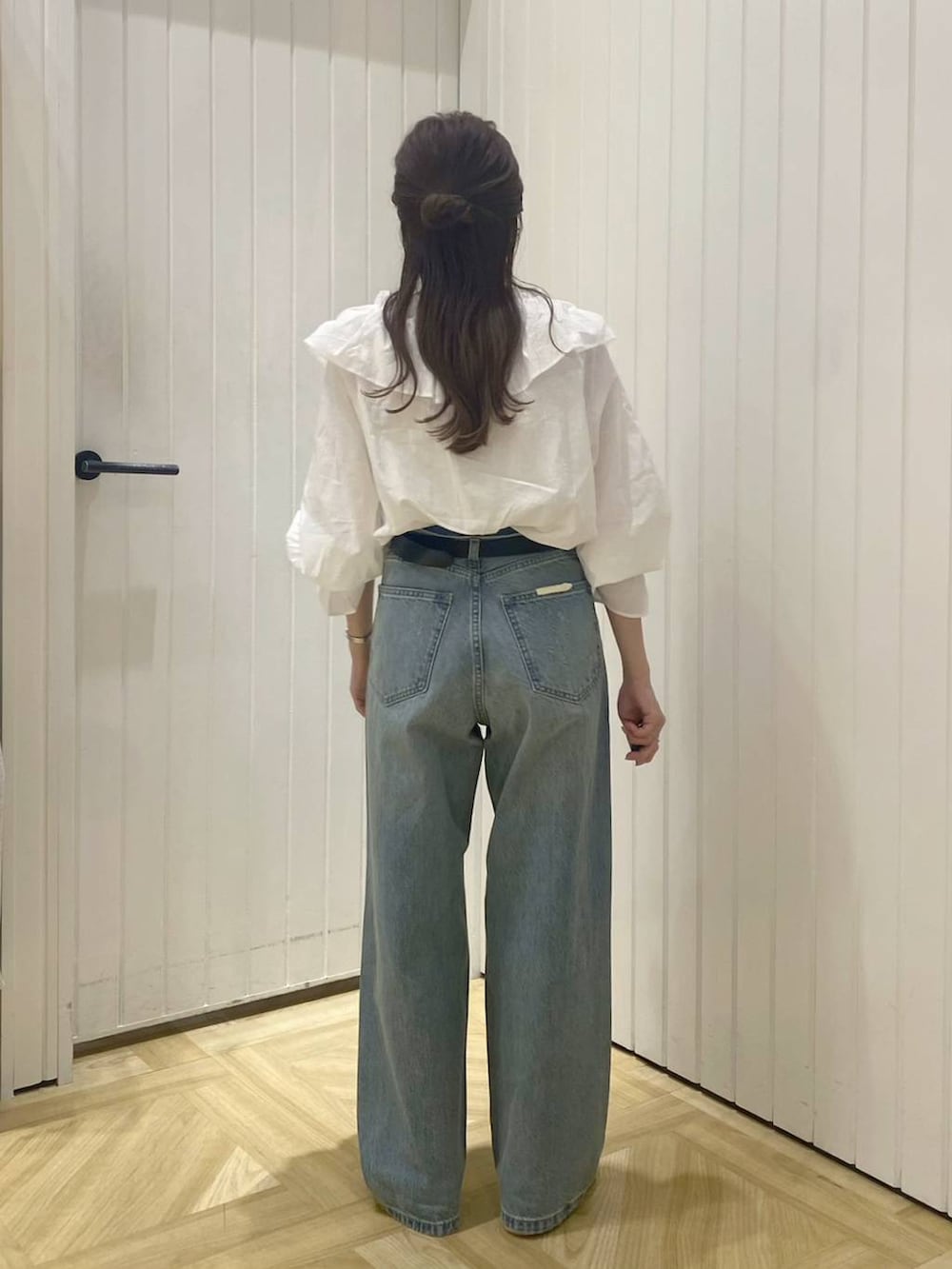 ホワイト系のブーツ、ブルー系のデニムパンツ、ホワイト系のキャミソールを着用したレディースの春コーディネートの5枚目の写真