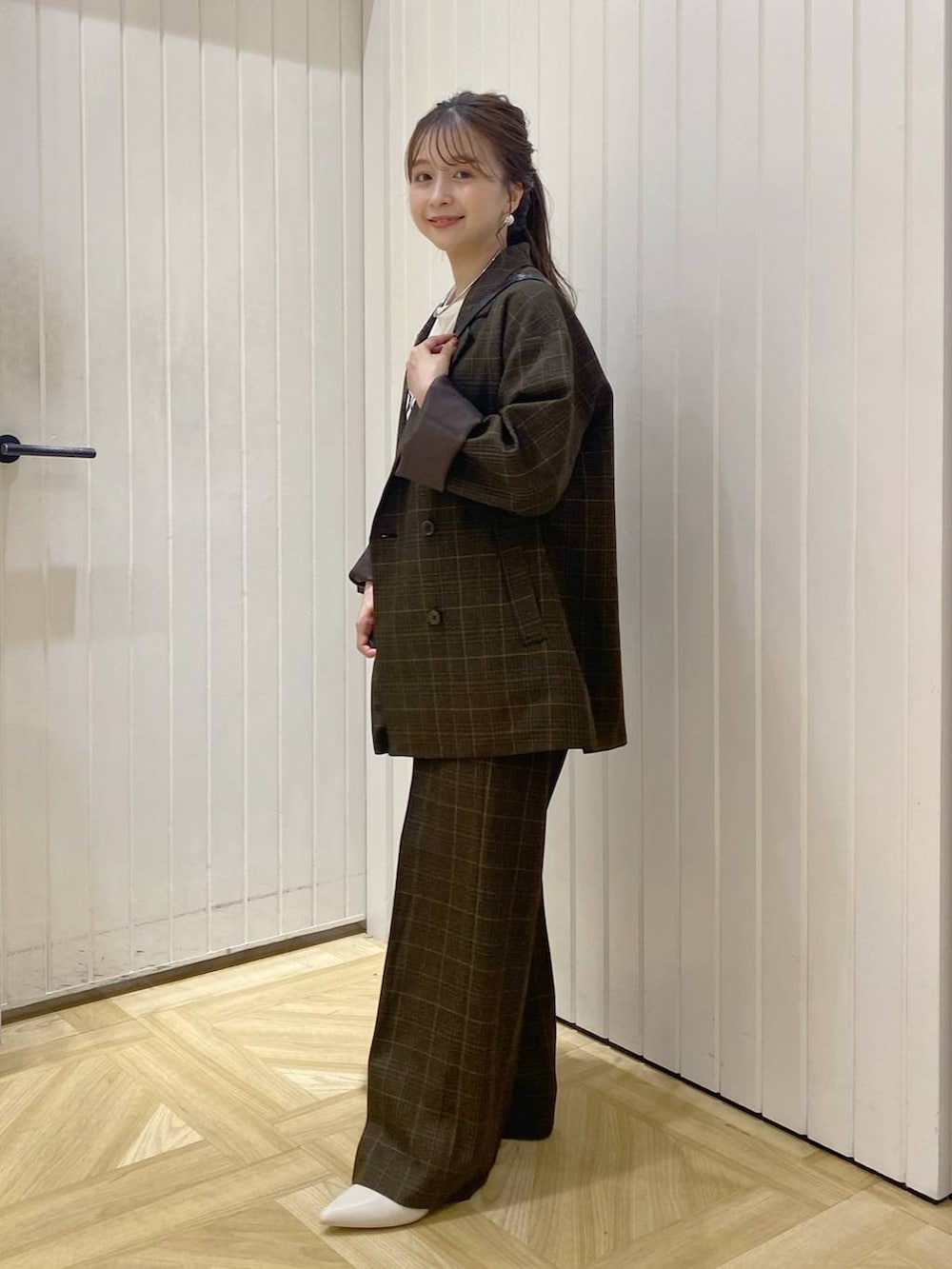 その他のテーラードジャケット、ブラウン系のスラックス、ブラック系のショルダーバッグを着用したレディースの秋コーディネートの2枚目の写真