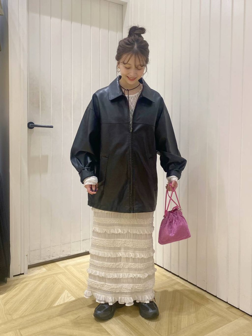 ブラック系のその他シューズ、ホワイト系のスカート、ピンク系のショルダーバッグを着用したレディースの秋コーディネートの2枚目の写真