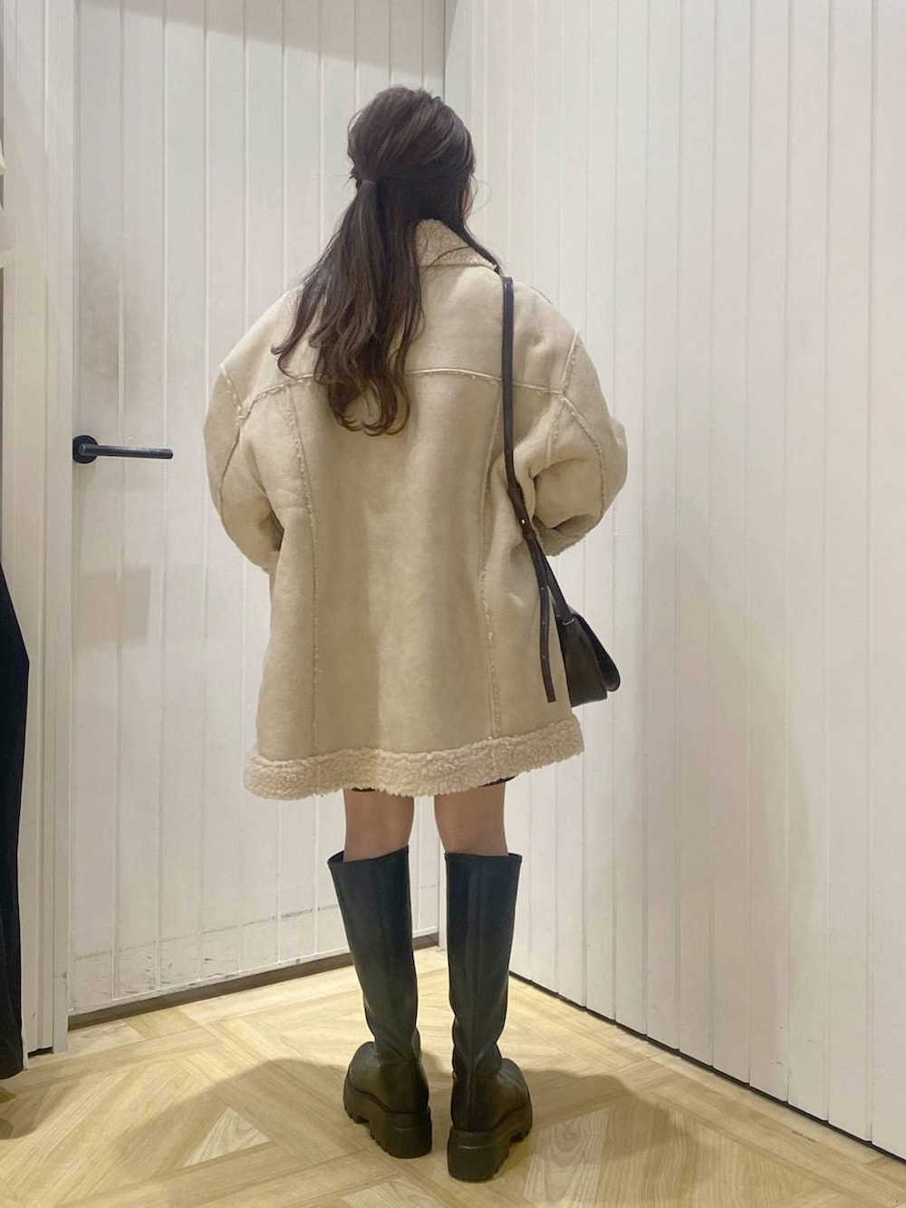 ベージュ系のブルゾン、ブラウン系のショルダーバッグ、ホワイト系のニット/セーターを着用したレディースの秋コーディネートの3枚目の写真