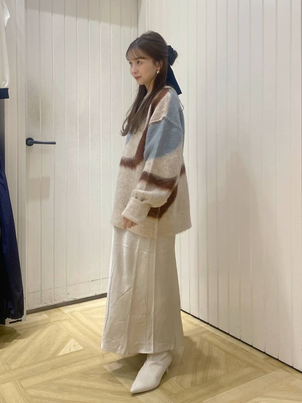 ホワイト系のスカート、ホワイト系のブーツ、ホワイト系のニット/セーターを着用したレディースの秋コーディネートの2枚目の写真