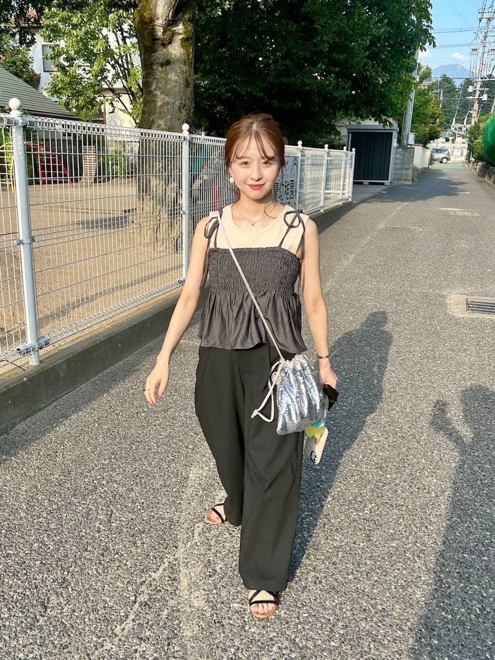 ブラック系のキャミソールを着用したレディースの夏コーディネートの2枚目の写真