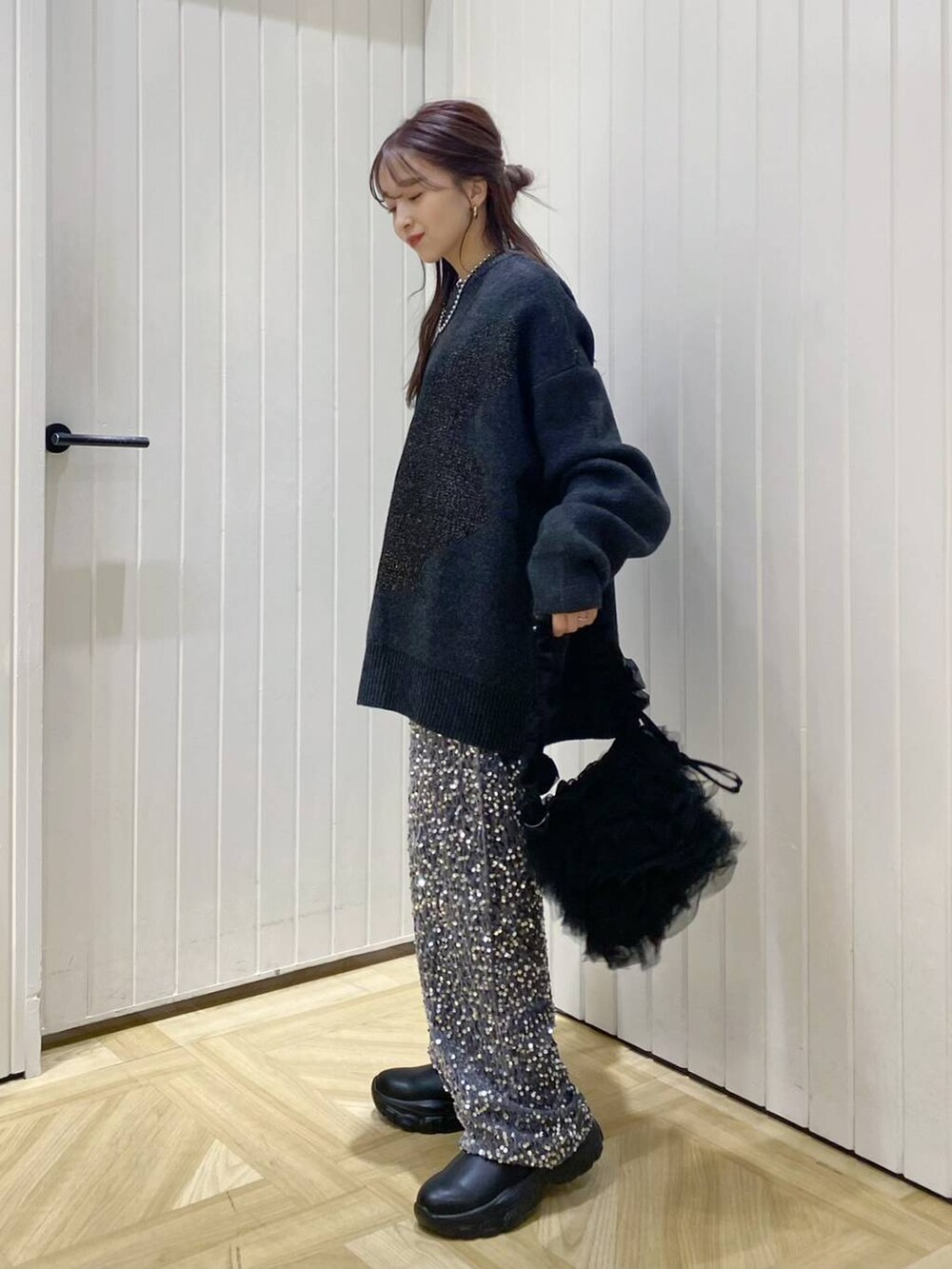 ブラック系のショルダーバッグ、ブラック系のブーツ、シルバー系のその他パンツを着用したレディースの冬コーディネートの3枚目の写真