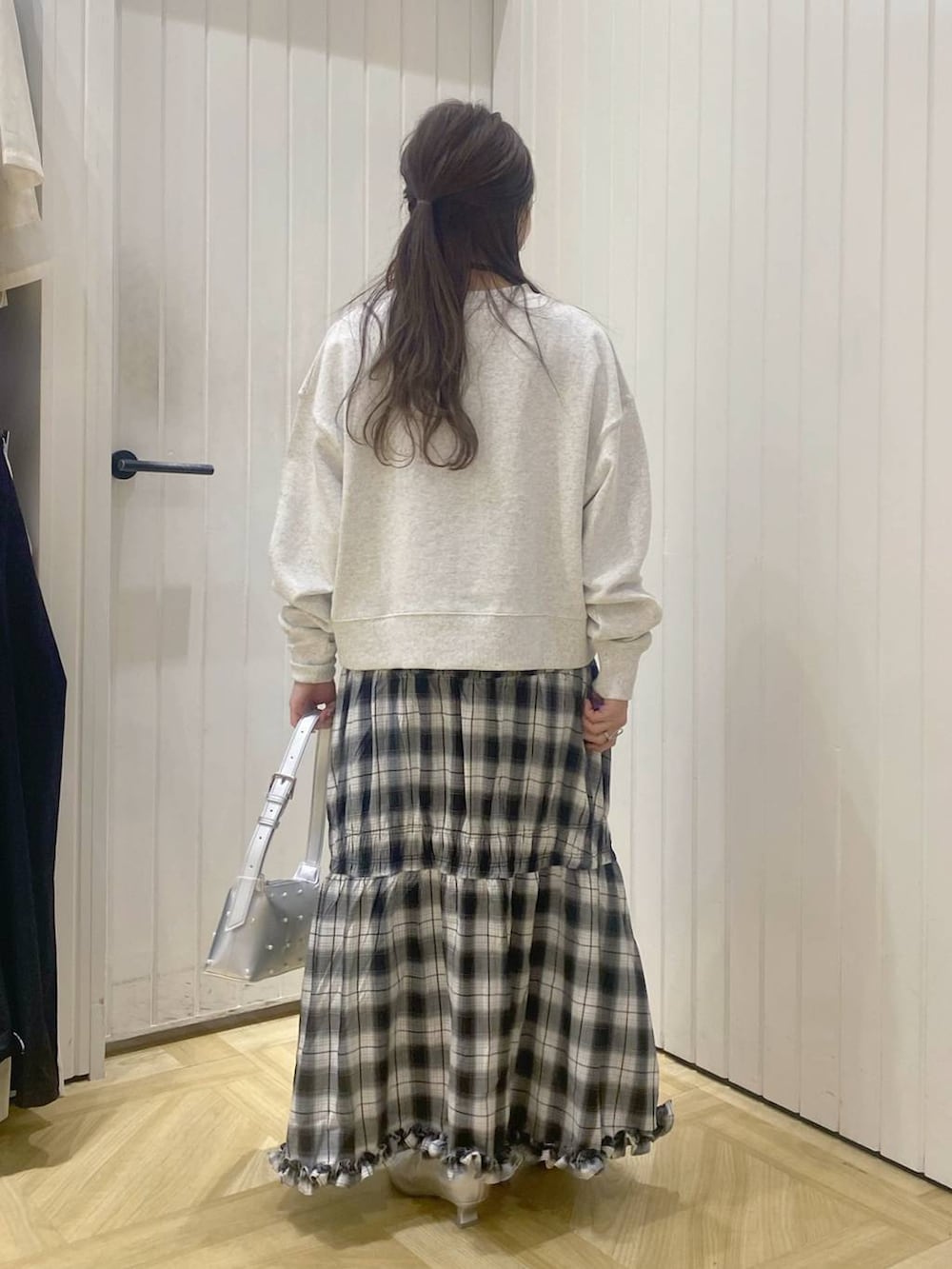 ブラック系のスカート、シルバー系のブーツ、グレー系のスウェットを着用したレディースの秋コーディネートの3枚目の写真