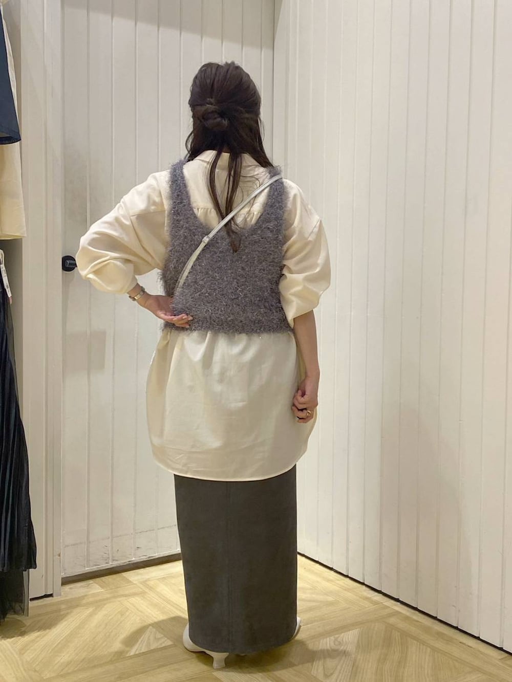 グレー系のキャミソール、シルバー系のショルダーバッグ、ホワイト系のブーツを着用したレディースの秋コーディネートの2枚目の写真