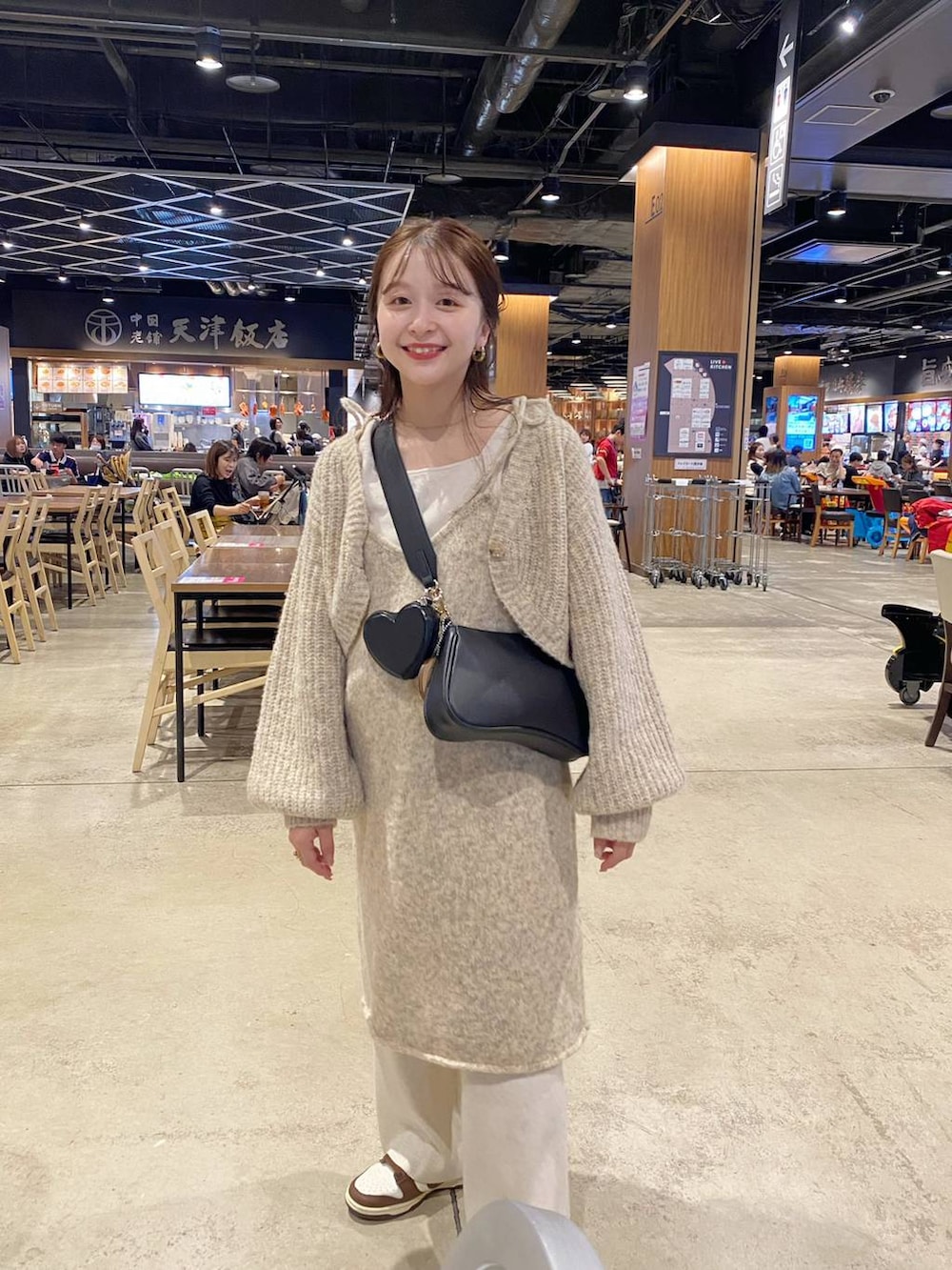 ホワイト系のワンピース、ホワイト系のタンクトップ、ブラック系のショルダーバッグを着用したレディースの秋コーディネートの3枚目の写真