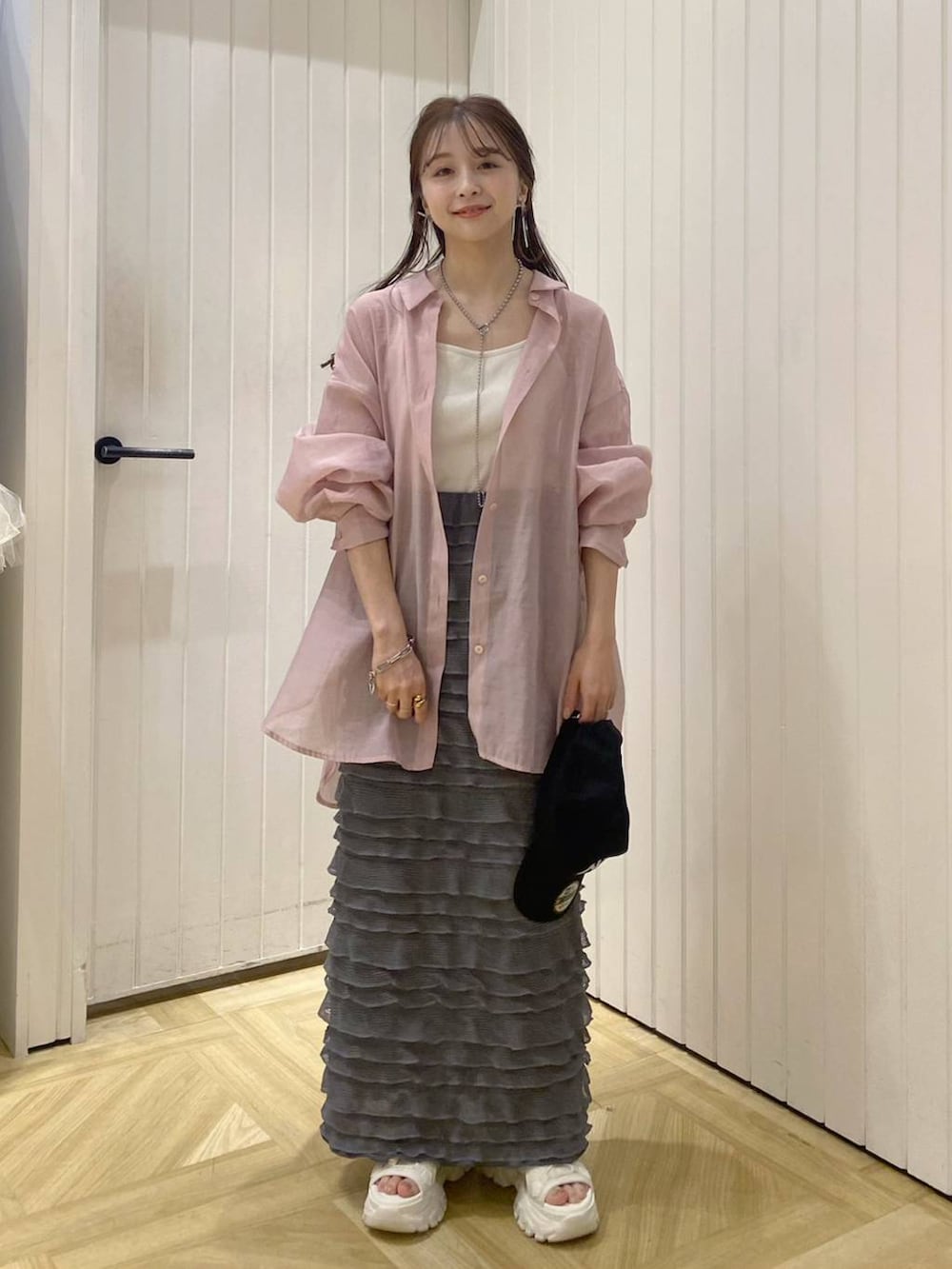 ホワイト系のTシャツ/カットソー、ホワイト系のサンダル、グレー系のスカートを着用したレディースの春コーディネートの3枚目の写真