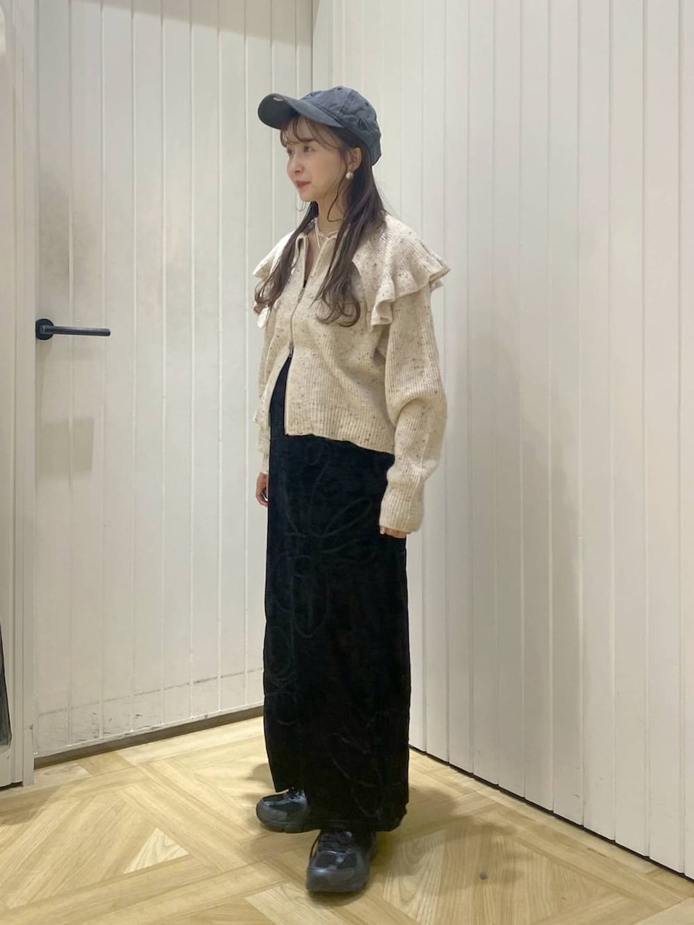 ブラック系のその他シューズ、ホワイト系のカーディガン/ボレロ、ブラック系のスカートを着用したレディースの秋コーディネートの3枚目の写真