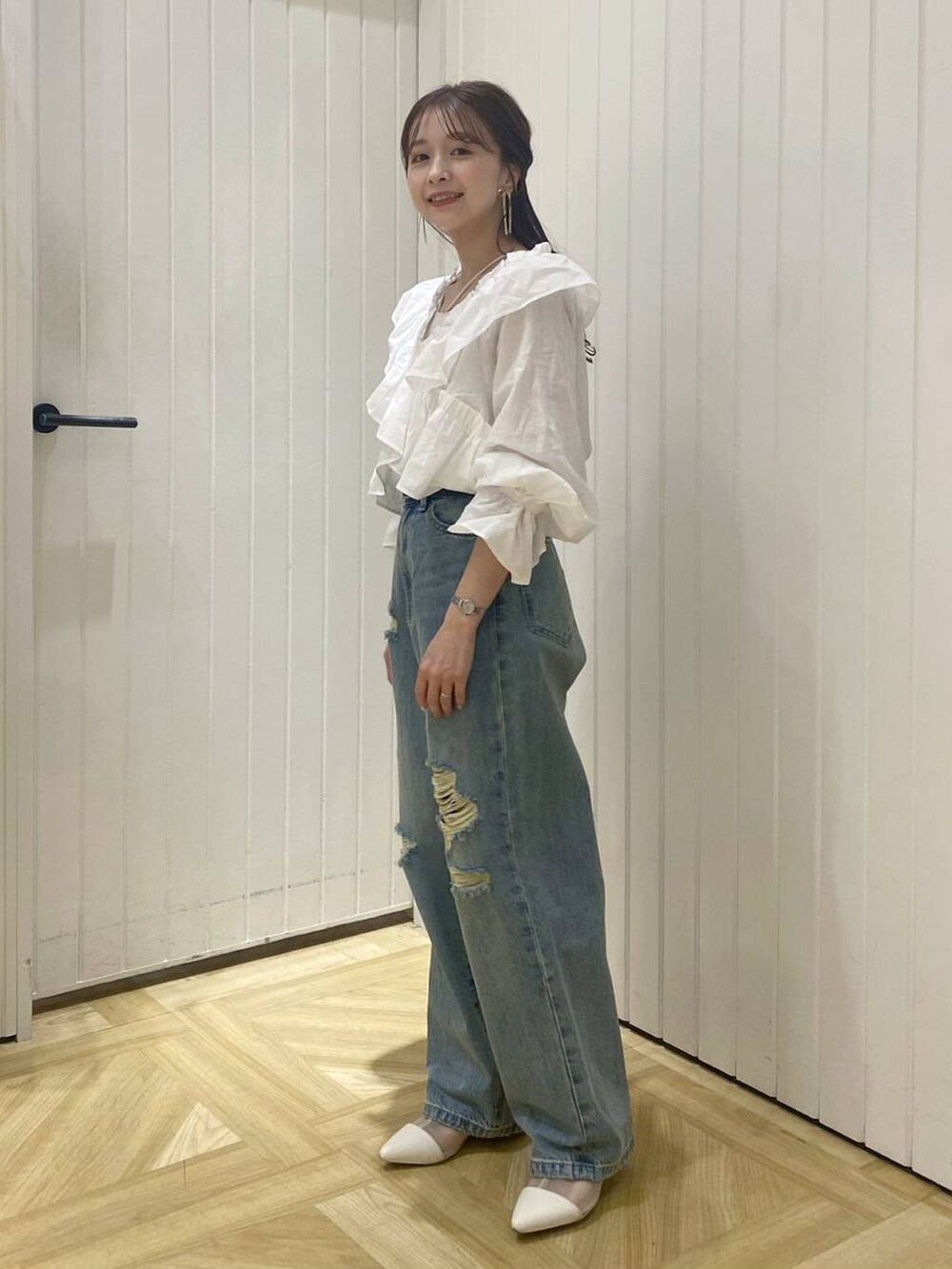 ホワイト系のブーツ、ブルー系のデニムパンツ、ホワイト系のキャミソールを着用したレディースの春コーディネートの4枚目の写真